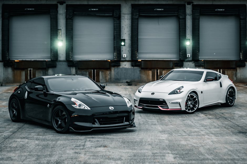 Dynamic shot of black and white sports cars parked in an industrial urban area.