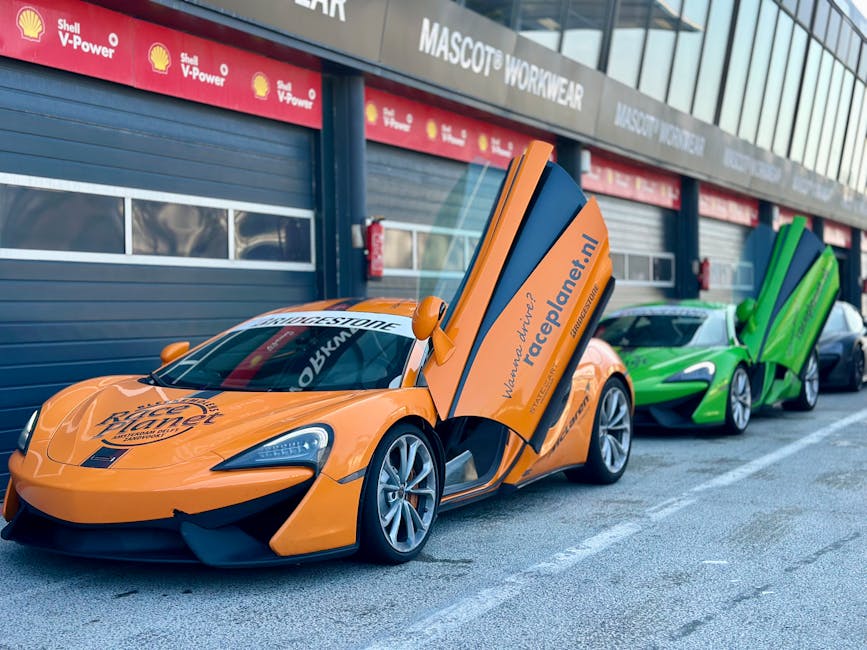 Row of vibrant sports cars at a race track showcasing their open butterfly doors and sleek designs.