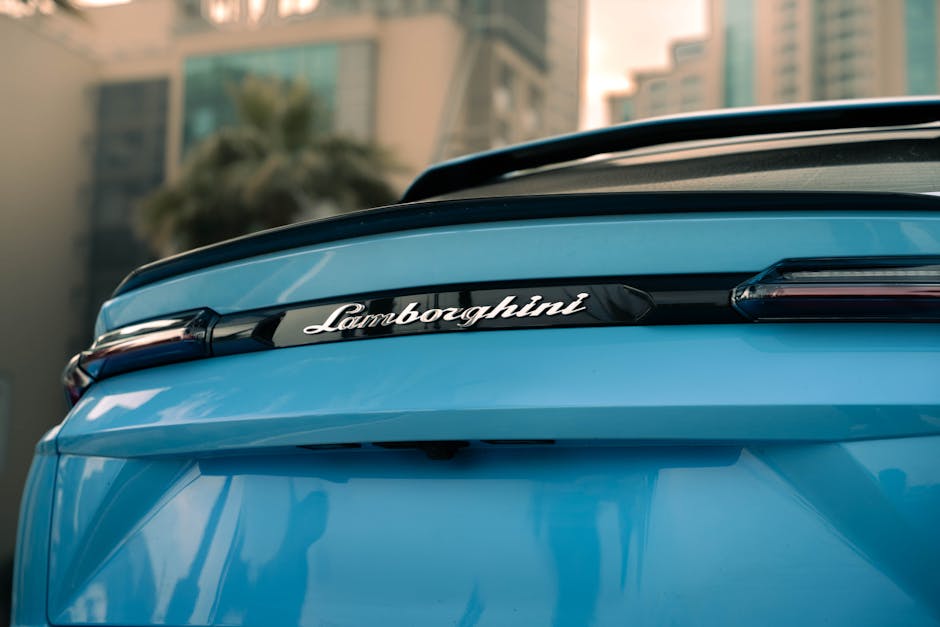 Close-up of a blue Lamborghini with urban high-rise background in Erbil.