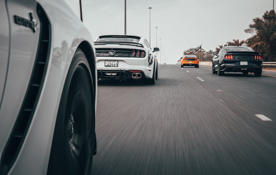 Dynamic view of sports cars racing on a highway, showcasing speed and motion